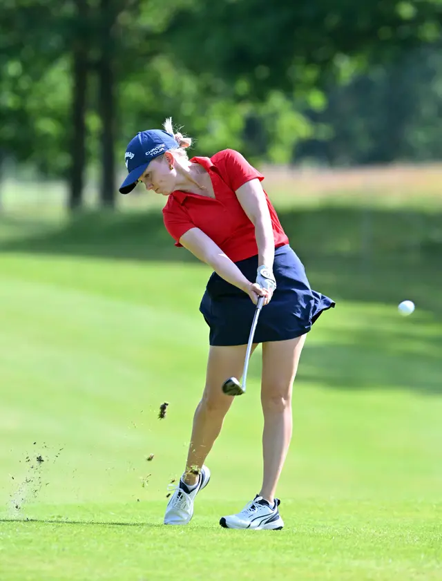 Celina Sattelkau: Eisenschlag mit Ball in der Luft, rotes Polo und dunkelblauer Rock