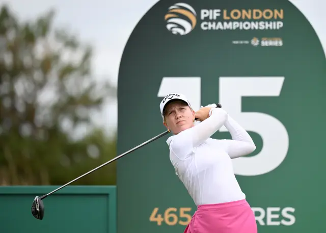 Celina Sattelkau: Abschlag vor grüner PIF-London-Championship-Tafel, weißes Longsleeve, pinker Rock