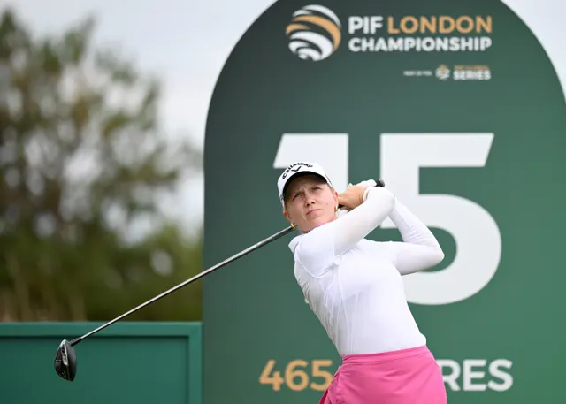 Celina Sattelkau: Driver-Finish vor PIF-London-Tafel im weißen Longsleeve mit pinkem Rock