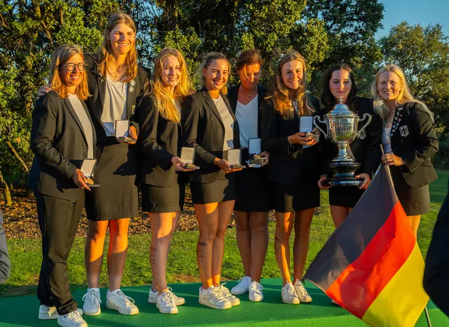Nationalteam in dunklen Blazern mit Medaillen und Deutschlandfahne bei der Siegerehrung