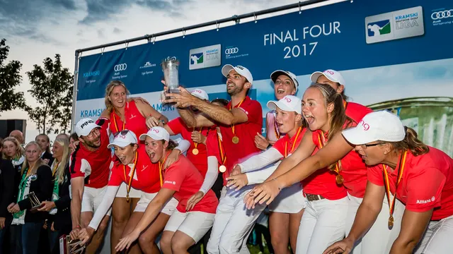 Jubelndes Team in roten Poloshirts mit Medaillen und Pokal vor der Final-Four-2017-Wand