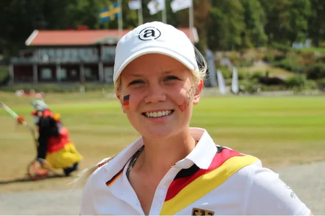Celina Sattelkau: im weiß-schwarzen Nationalpolo mit Deutschlandflaggen auf den Wangen, lachend