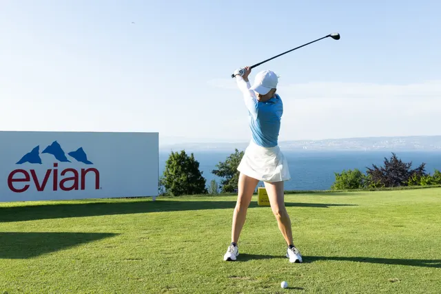 Celina Sattelkau: im hellblauen Polo beim Abschlag vor der Evian-Bande mit Seeblick