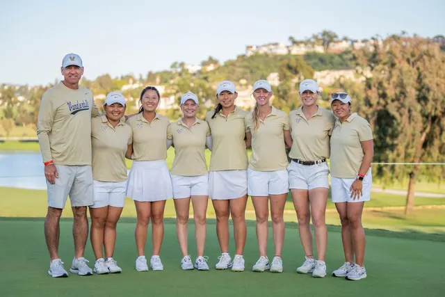 Vanderbilt-Golfteam mit Coach in goldenen Polos und weißen Shorts nebeneinander auf dem Platz
