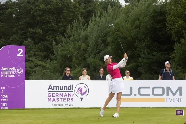 Celina Sattelkau: Abschlag vor Amundi-German-Masters-Tafel im pinken Polo mit Zuschauerinnen