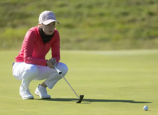 Celina Sattelkau: Hockt mit Putter beim Grünlesen, pinkes Oberteil und weiße Hose
