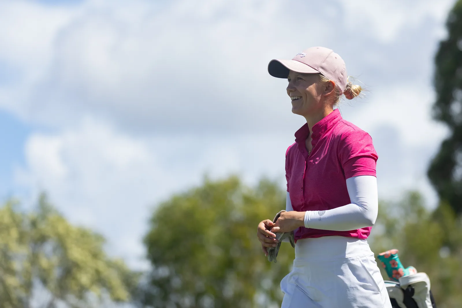 Celina Sattelkau lächelnd im pinken Top mit rosa Cap