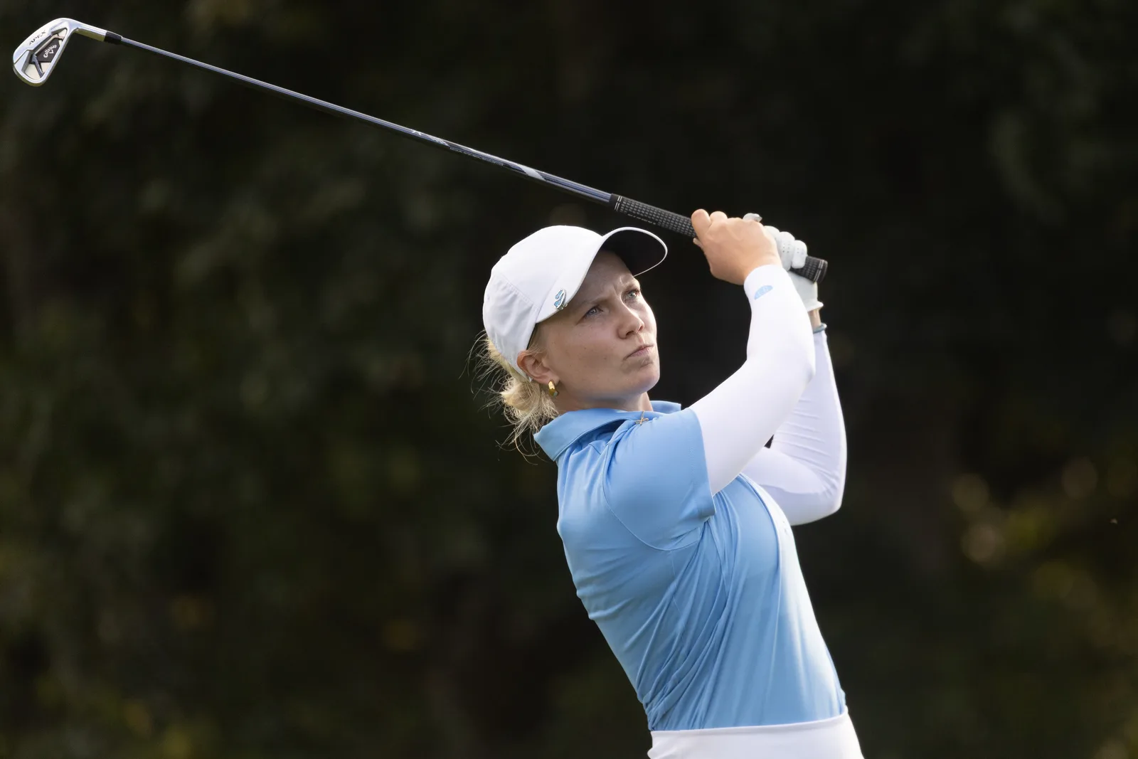 Celina Sattelkau im Schwungfinish, hellblaues Polo mit weißem Cap