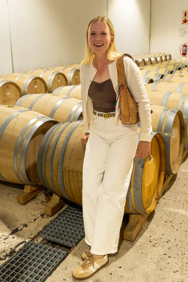 Celina Sattelkau: In cremefarbenem Outfit mit Handtasche zwischen Weinfässern im Weingut