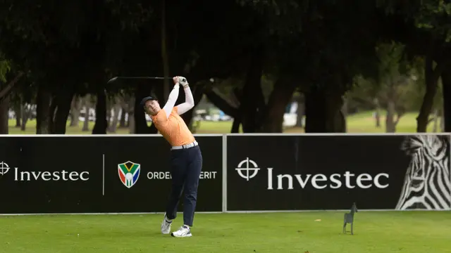 Celina Sattelkau: Abschlag im orangen Polo vor Investec-Banden in Südafrika