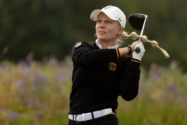 Celina Sattelkau: Driver-Finish im schwarzen Germany-Pullover, Flechtzopf, violette Blumen im Vordergrund