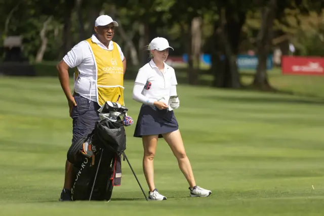 Celina Sattelkau: Geht neben Caddie in gelber Weste mit Bag über den Platz
